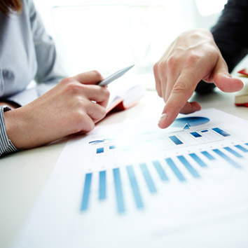 A colour picture of people analysing business charts, as a metaphor for understanding market trends in the property sector by Oakford Group